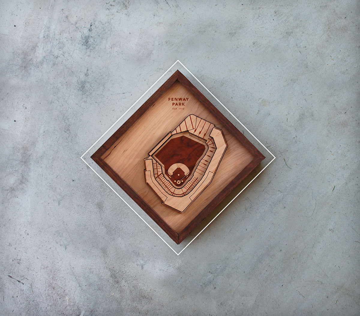 A framed Stadium Graph piece of Fenway Park, photographed on concrete